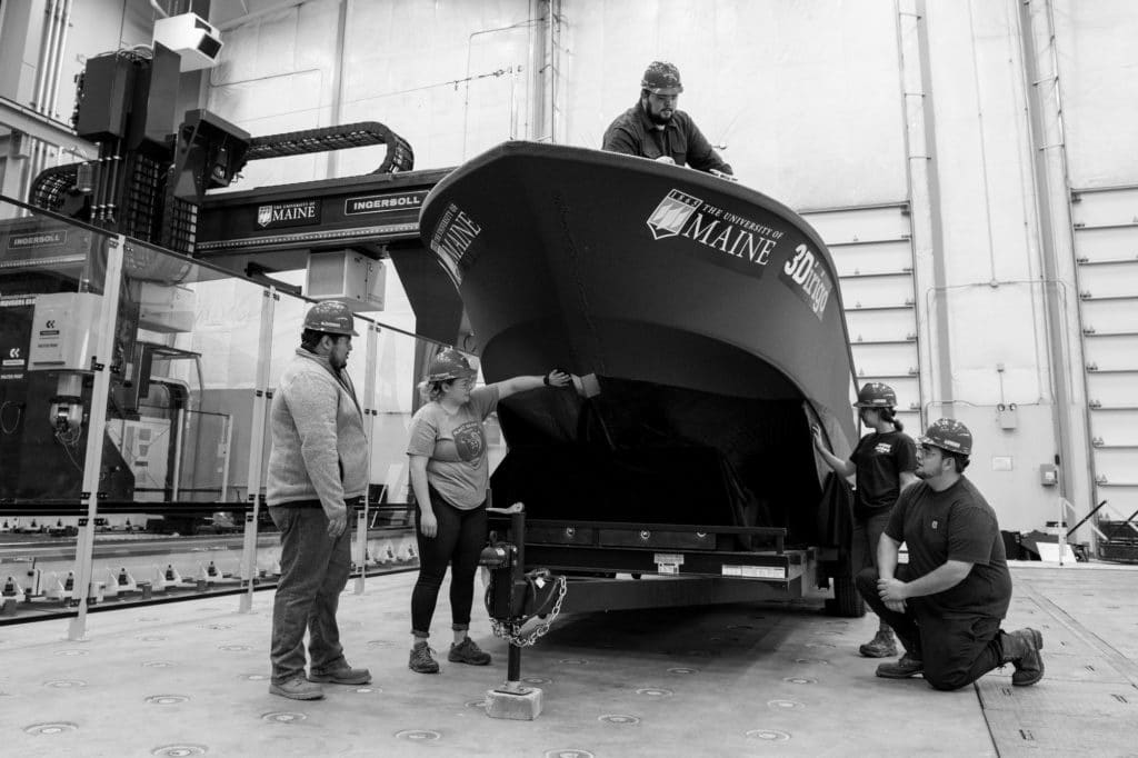 Dagher and his team next to a 3d printed boat